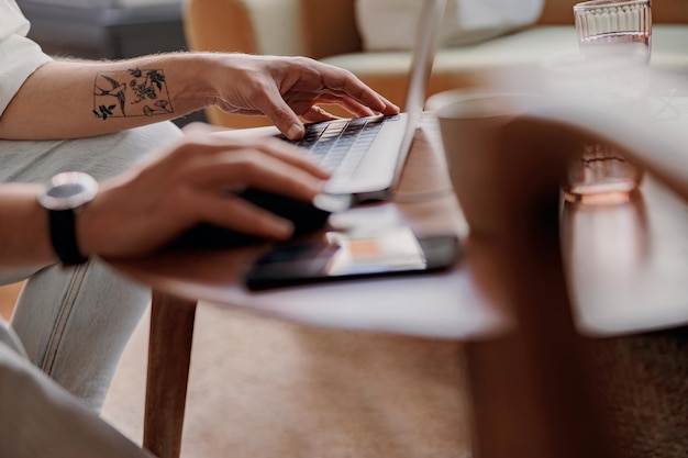 Close-up de mão masculina trabalhando em um teclado de laptop de um café aconchegante Foto de alta qualidade