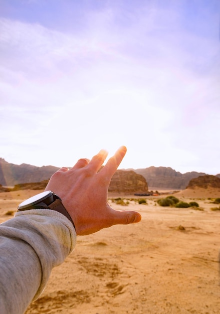 Foto close-up de mão no deserto contra o céu