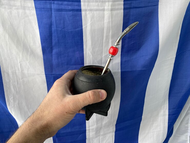 Foto close-up de mão segurando bandeira contra a parede azul