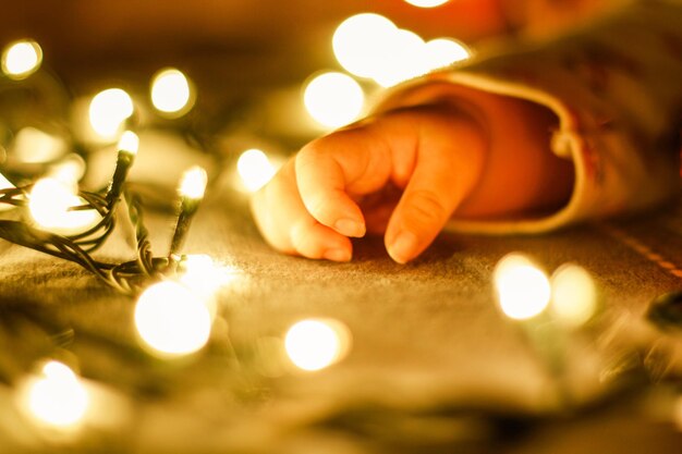 Foto close-up de mão segurando luzes de natal iluminadas