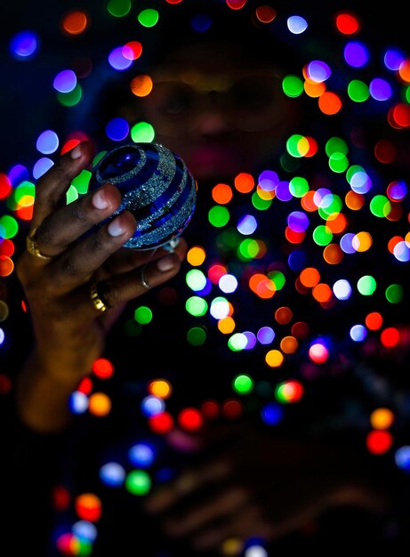 Foto close-up de mão segurando luzes de natal iluminadas