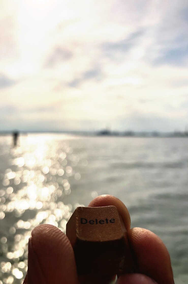 Foto close-up de mão segurando sorvete sobre o mar contra o céu