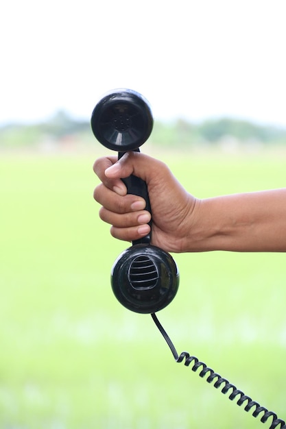 Close-up de mão segurando telefone contra o céu