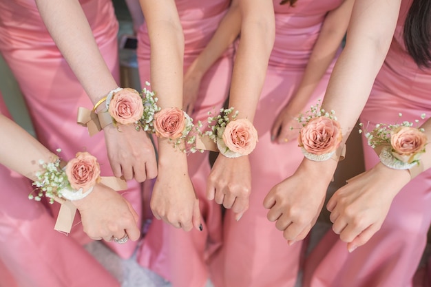 close-up de mãos dama de honra com flor e vestido rosa