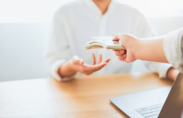 Foto close-up de mãos dando dólares pagar compensação do trabalho