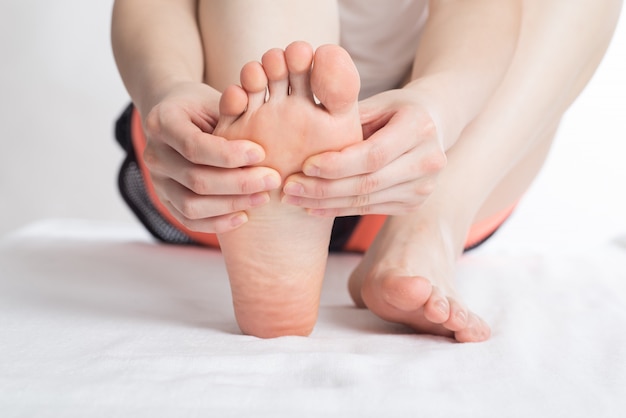 Close-up de mãos femininas, fazendo massagem nos pés
