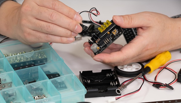 Foto close-up de mãos montando brinquedos educacionais robóticos conceito de educação stem