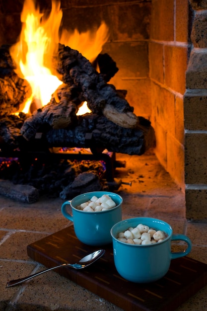 Close-up de marshmallows em copos junto à lareira