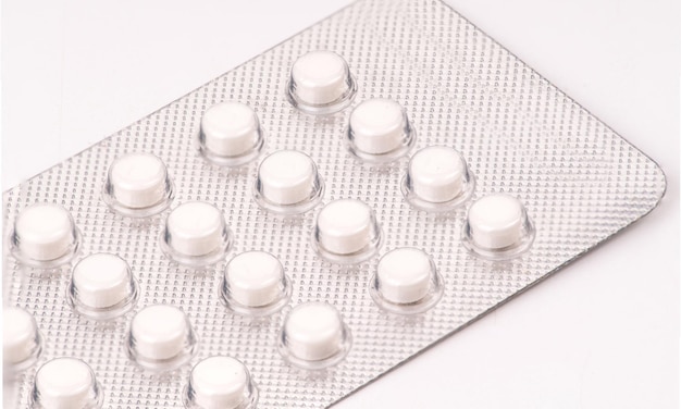 Close-up de medicamentos em blister em fundo branco