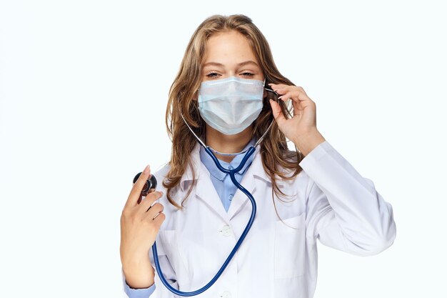 Close-up de médico segurando dentaduras contra fundo branco