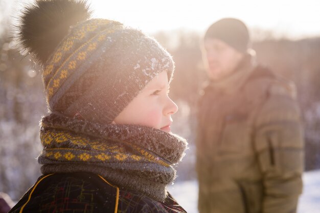 Close-up de menino pequeno no pôr do sol de inverno ao ar livre