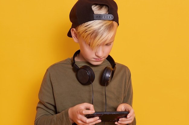 Close-up de menino usando telefone celular enquanto estiver jogando jogos on-line