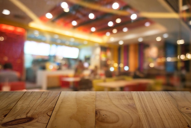 Foto close-up de mesa de madeira contra luzes iluminadas em um restaurante