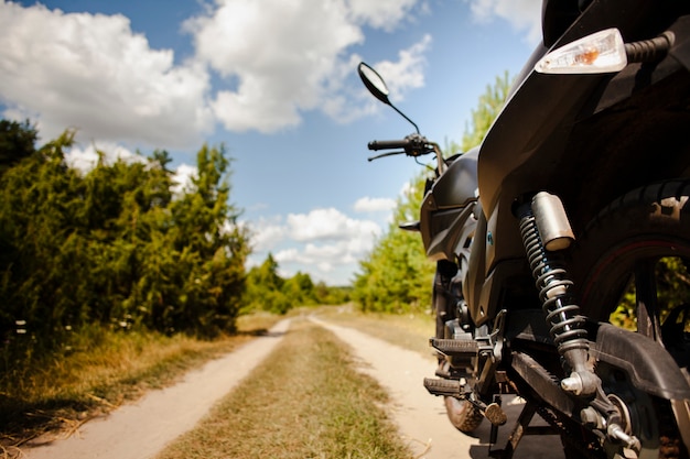 Foto close-up de moto traseira na estrada de terra