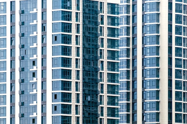 Close-up de muitas janelas na fachada de um novo prédio de apartamentos. Para o fundo.