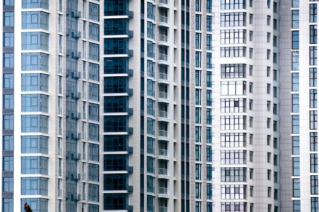 Close-up de muitas janelas na fachada de um novo prédio de apartamentos. Para o fundo.