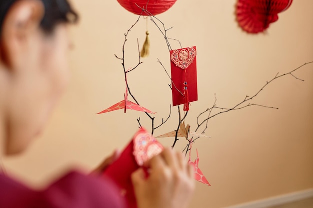 Close-up de mulher asiática decorando árvore no ano novo chinês