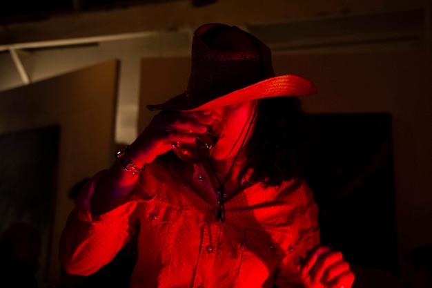 Foto close-up de mulher bebendo álcool na sala escura