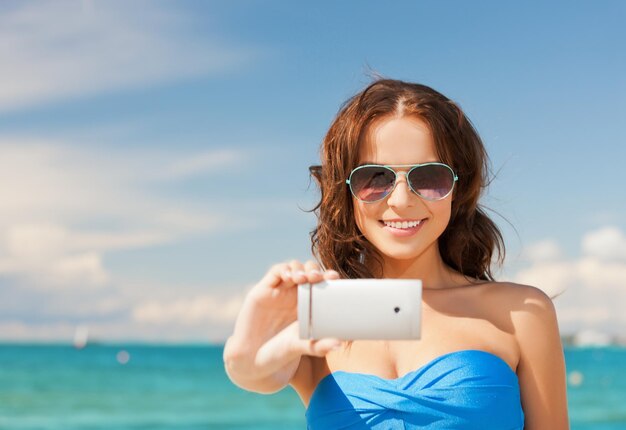 close-up de mulher bonita na praia com telefone