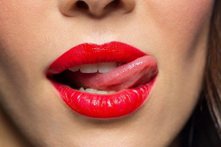 Foto close-up de mulher com batom vermelho lambendo lábios