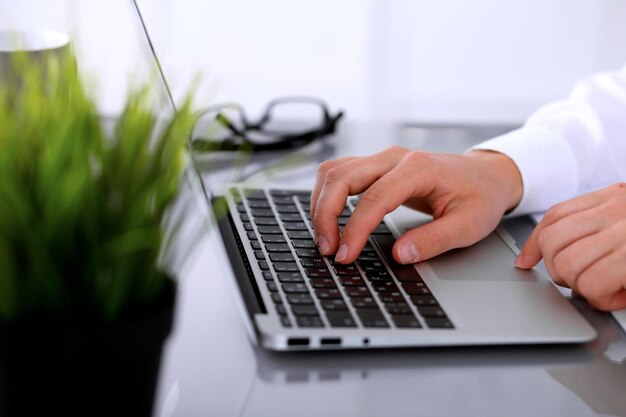 Close-up de mulher de negócios está digitando no computador portátil.