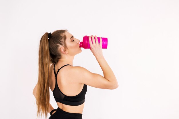 Close-up de mulher fitness segurando uma garrafa de água em branco