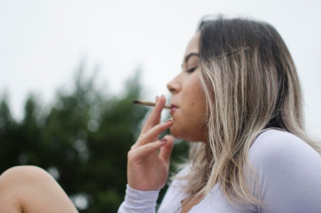 Foto close-up de mulher fumando maconha