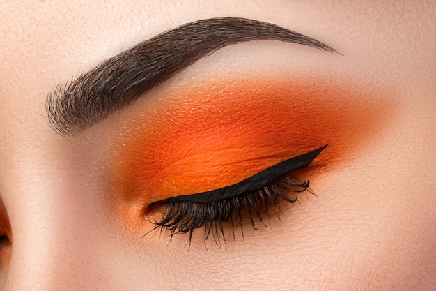 Close-up de mulher maquiagem olho com lindos olhos laranja esfumados