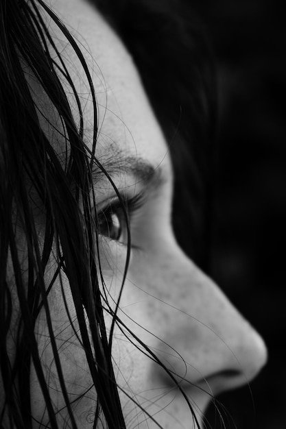 Close-up de mulher olhando para longe contra um fundo preto