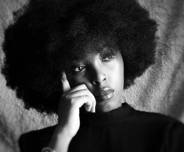 Close-up de mulher pensativa com cabelo crespo