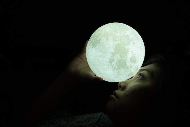 Foto close-up de mulher segurando equipamento de iluminação iluminado à noite