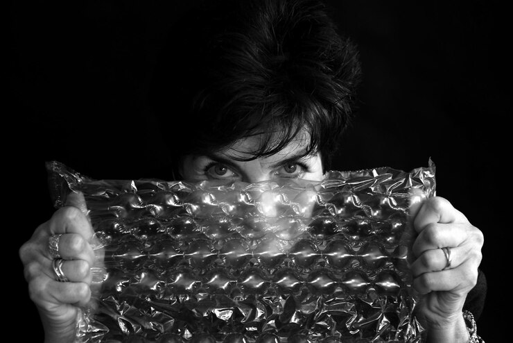 Foto close-up de mulher segurando luzes iluminadas contra fundo preto