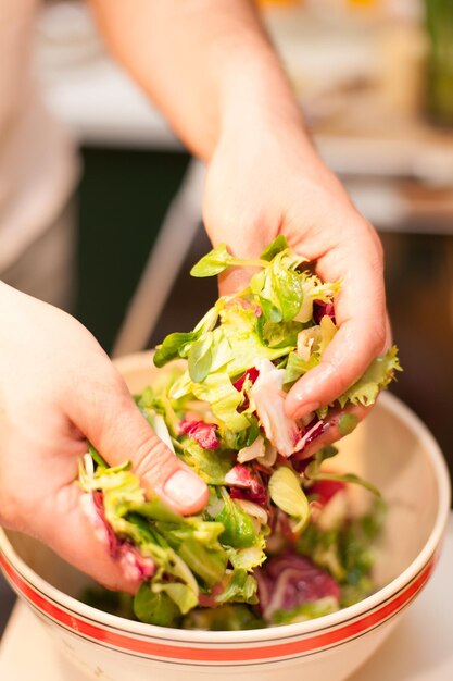 Foto close-up de mulher segurando salada sobre a tigela