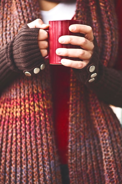 Foto close-up de mulher segurando uma caneca vermelha