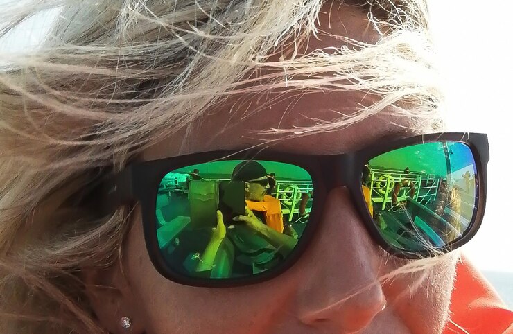 Foto close-up de mulher usando óculos de sol com o reflexo de um homem no vidro
