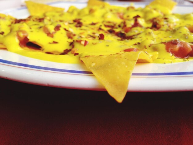 Foto close-up de nachos com queijo servidos em prato na mesa