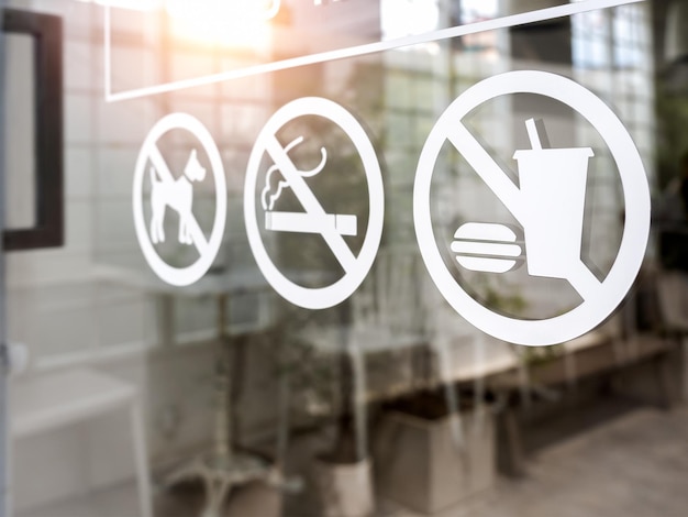 Foto close-up de nenhum alimento e bebida ícone animal de estimação e nenhum tabagismo proibido sinal adesivo branco na porta da frente de vidro de café ou restaurante