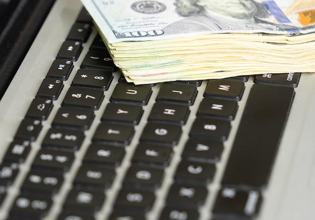 Close-up de notas de dólar no conceito de negócio de teclado de laptop