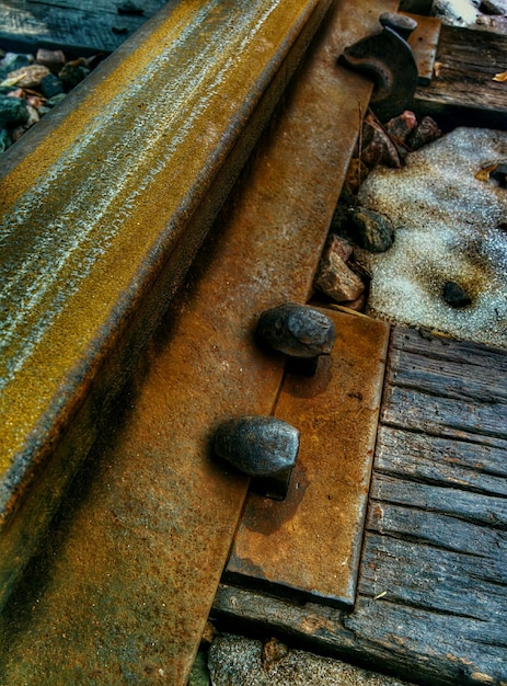 Close-up de nozes em trilhos de trem enferrujados