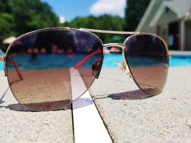 Close-up de óculos de sol contra a piscina