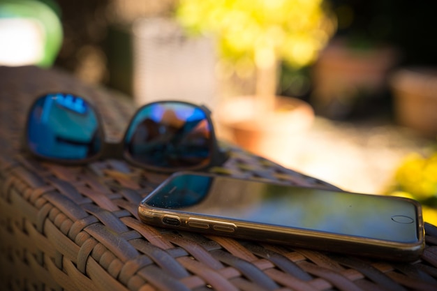 Foto close-up de óculos de sol e smartphone na mesa