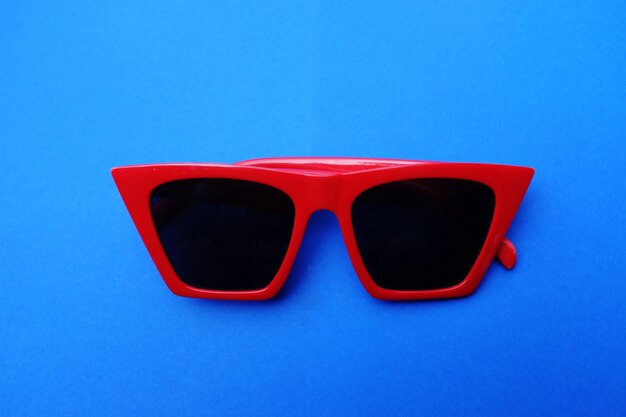 Close-up de óculos de sol vermelhos contra fundo azul