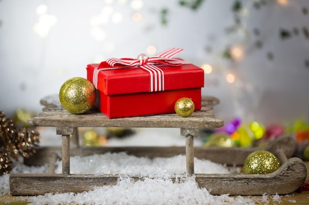 Close-up de ornamentos de Natal e presente em trenó na mesa