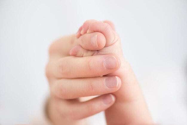 Close-up de pai e bebê de mãos dadas
