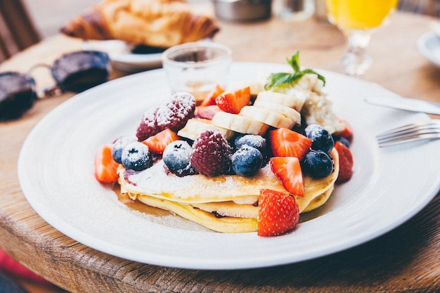 Close-up de panqueca com frutas em prato na mesa