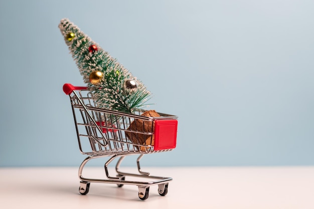 Close-up de pequena árvore de Natal no carrinho de compras