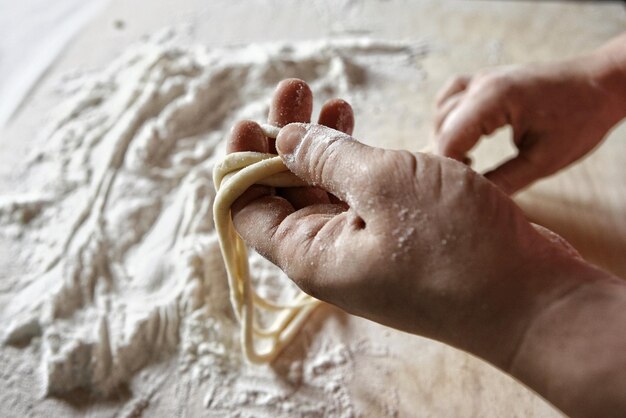 Foto close-up de pessoa preparando comida de pasta fresca toscana pici