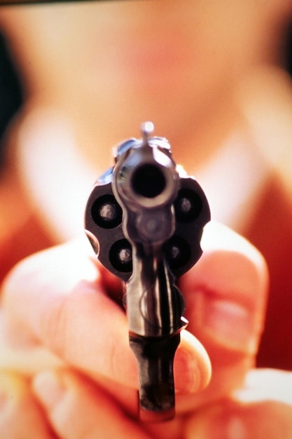 Close-up de pessoa segurando uma arma