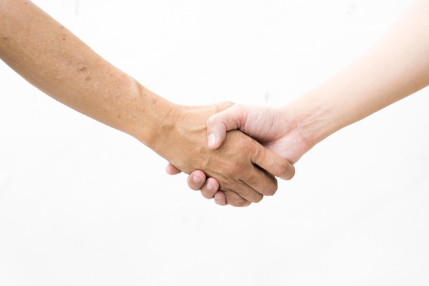 Foto close-up de pessoas apertando as mãos contra um fundo branco