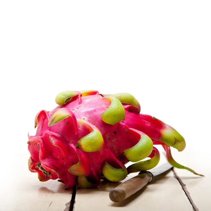 Foto close-up de pitaya e faca na mesa